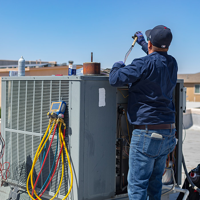 technician-repairing-air-conditioner-unit-at-residential-property-roof-el-paso-tx