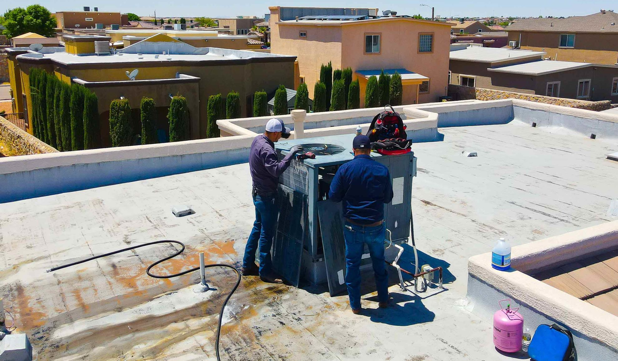 group-of-hvac-technicians-on-top-of-residential-property-repairing-unit-el-paso-tx